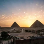 Panoramic sunset view over the Giza pyramid complex from a rooftop vantage point - Pyramids Cairo tour