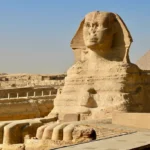 Close-up profile view of the Great Sphinx of Giza with the pyramid in the background - Pyramids Cairo tour