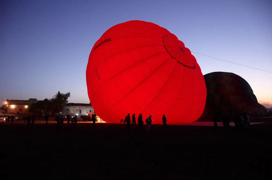Hot air balloons inflating before sunrise in Luxor