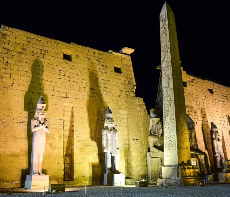 Luxor Temple pylon, colossi and obelisk floodlit at night