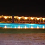Resort pool glowing at night, a festive scene on all inclusive New Year holidays in Egypt