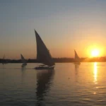 Felucca sailing into a Luxor sunset, a cheap Christmas vacation moment on the Nile - cheap christmas vacations