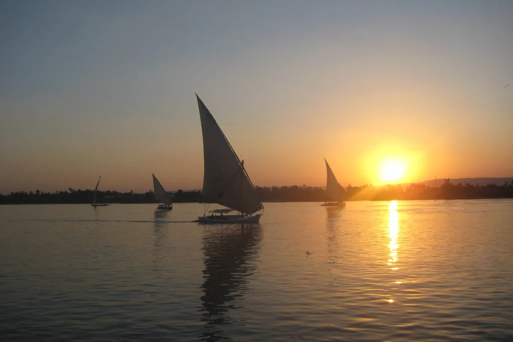 Felucca sailing into a Luxor sunset, a cheap Christmas vacation moment on the Nile - cheap christmas vacations
