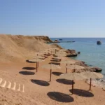 Empty sunlit beach with parasols, one of the best Christmas beach vacations on Egypt's Red Sea