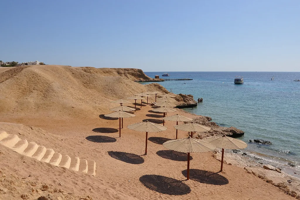 Empty sunlit beach with parasols, one of the best Christmas beach vacations on Egypt's Red Sea