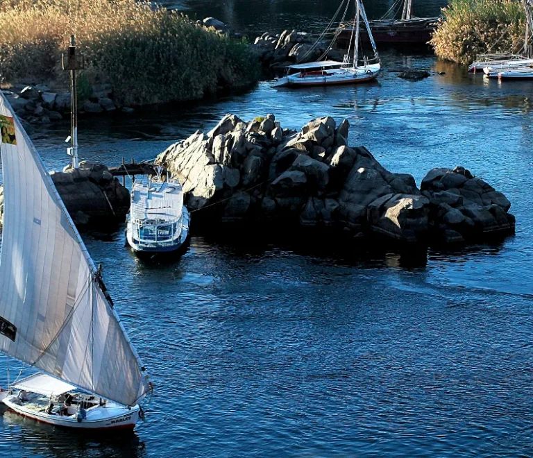 Felucca ride Aswan: white lateen sail beside granite rocks on the Nile