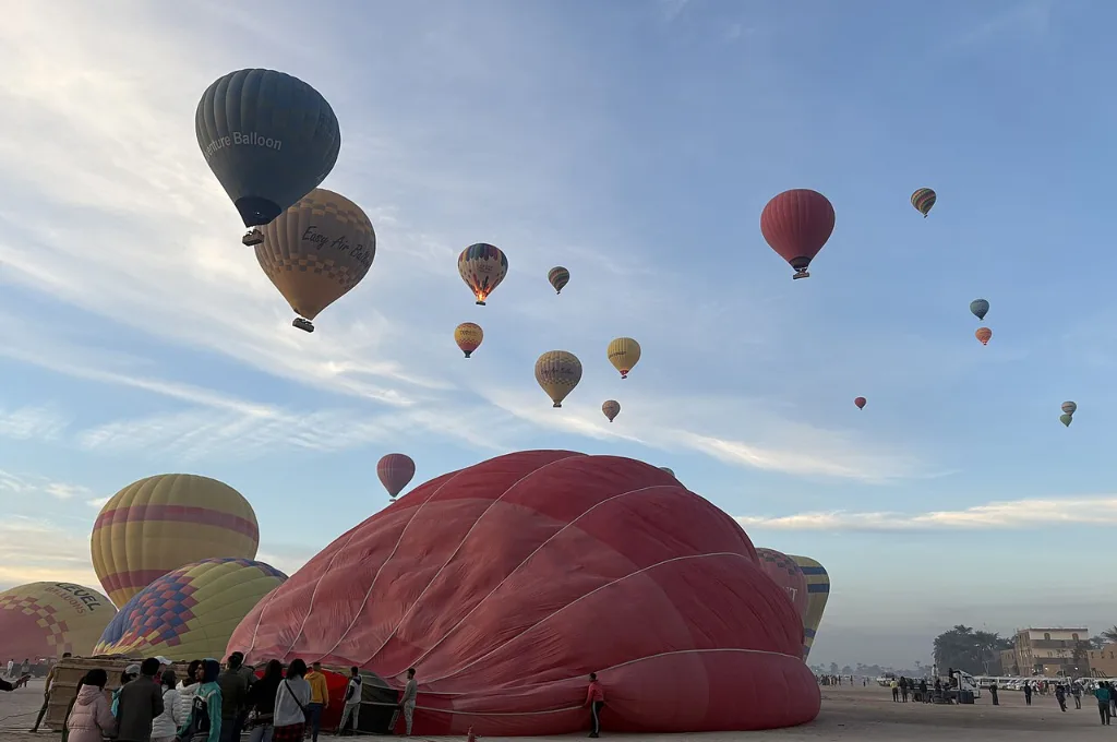 Group on a private hot air balloon ride over Luxor green fields