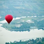 Hot air balloon Luxor price guide: a balloon floating above green Nile Valley fields at sunrise