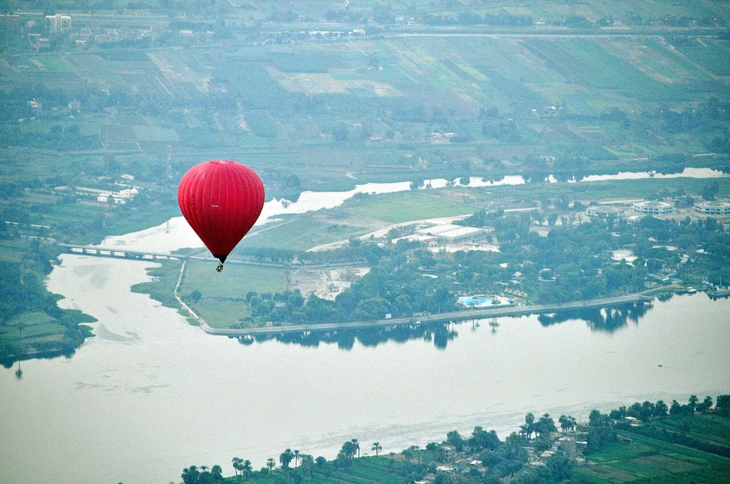 Hot air balloon Luxor price guide: a balloon floating above green Nile Valley fields at sunrise