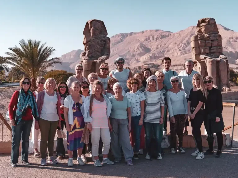 Travelers posing near the Colossi of Memnon in Luxor, Egypt