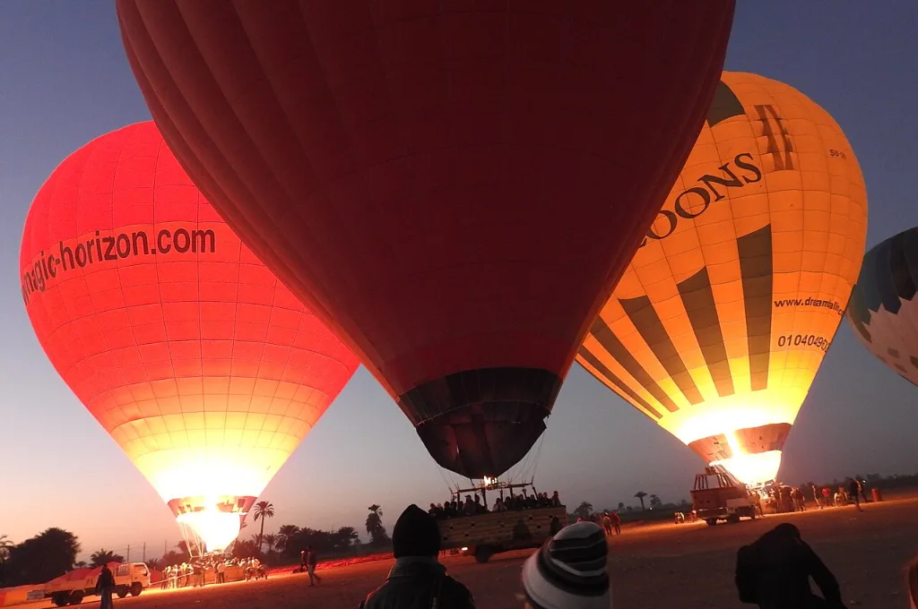 Luxor balloon tour: crews inflating hot air balloons at the West Bank launch field