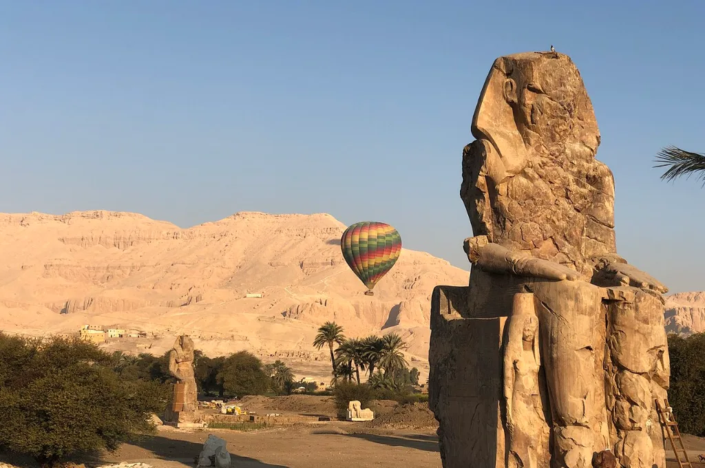 Luxor hot air balloon tour: a balloon drifting beside the Colossi of Memnon