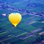 Luxor hot air balloon tour: a balloon drifting over the West Bank farmland at sunrise
