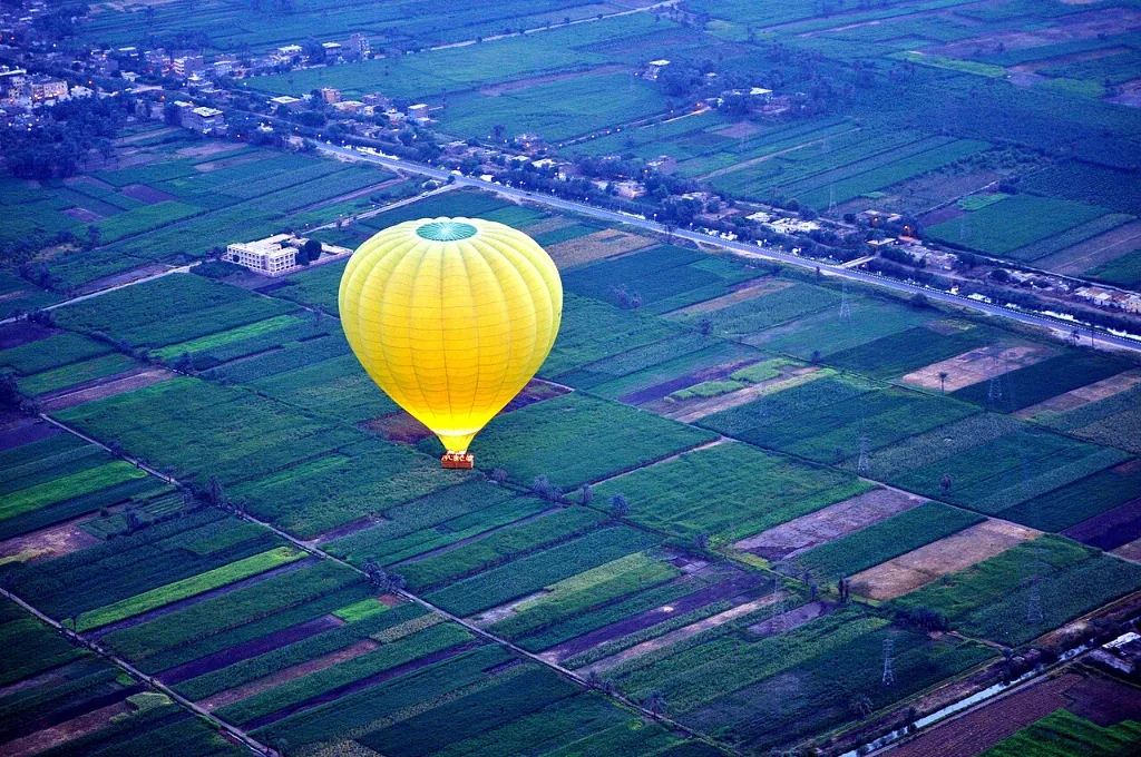 Luxor hot air balloon tour: a balloon drifting over the West Bank farmland at sunrise