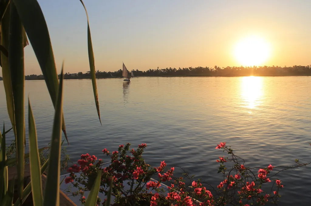 Nile sunset with a felucca in the distance, a fitting end to the best Christmas river cruises