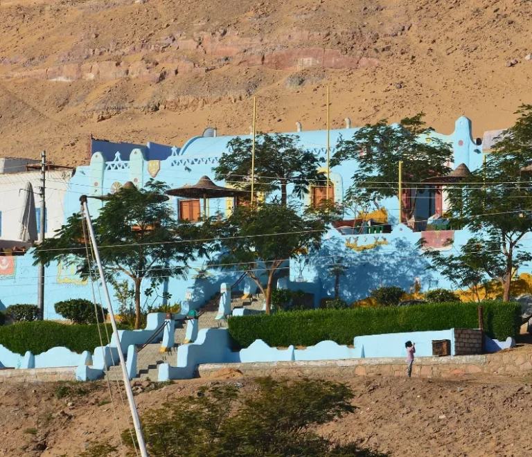 Colourful Nubian village Aswan houses on the Nile bank below the desert