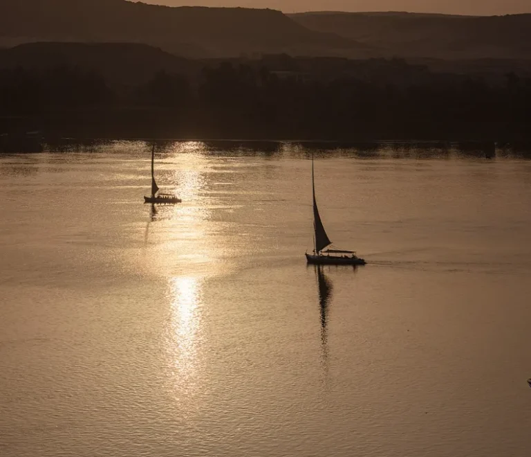 Warm Christmas vacations in Egypt: golden afternoon light on the Nile at Aswan with felucca sails